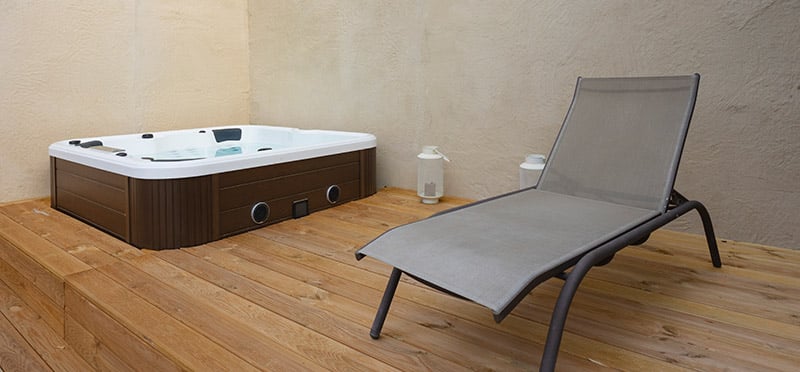 Jacuzzi and deck chair on wooden floor